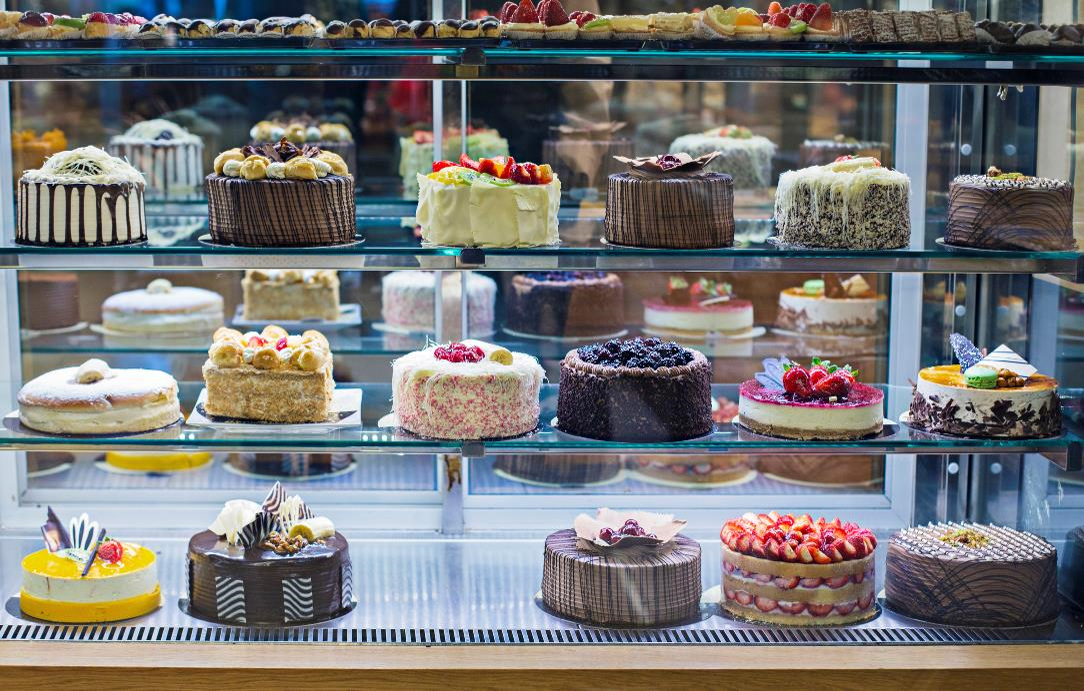 Assorted cakes on display in case at bakery