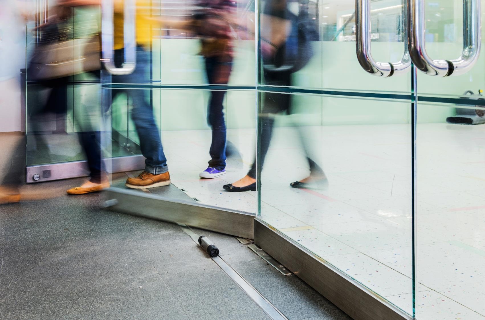 in motion photo of people walking through a door