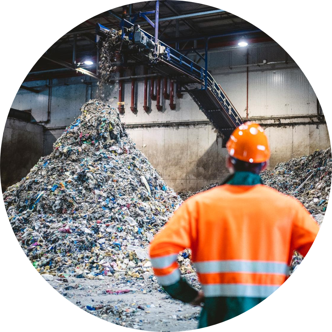 Man staring at a pile of trash in a recycling center