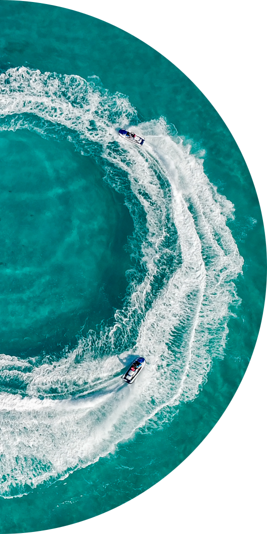 half circle image of an aerial view of jetski riders doing circles in the water