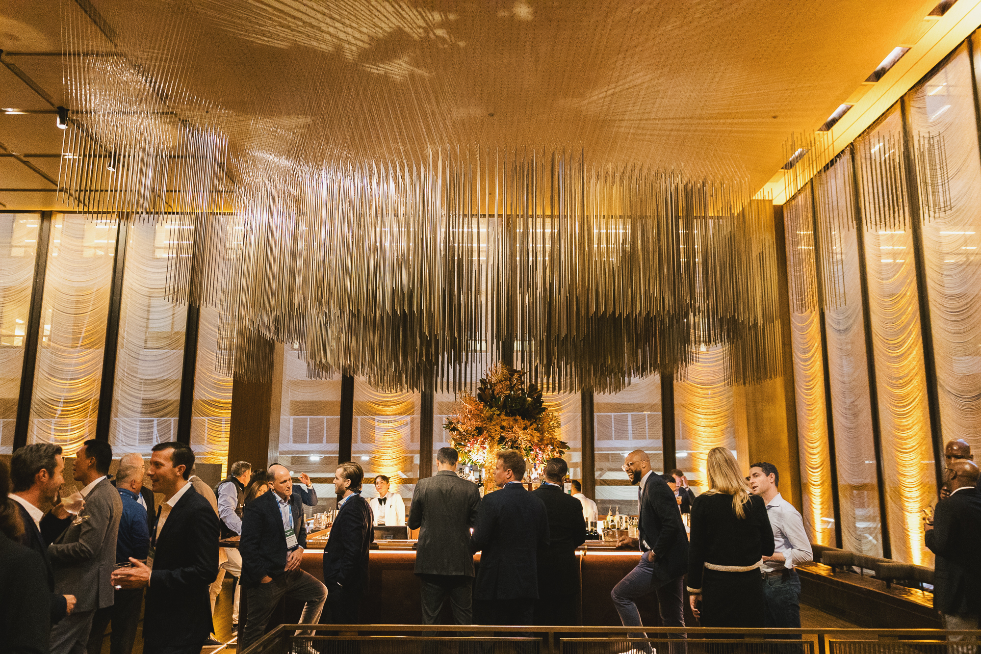 group of people at a reception talking around the bar