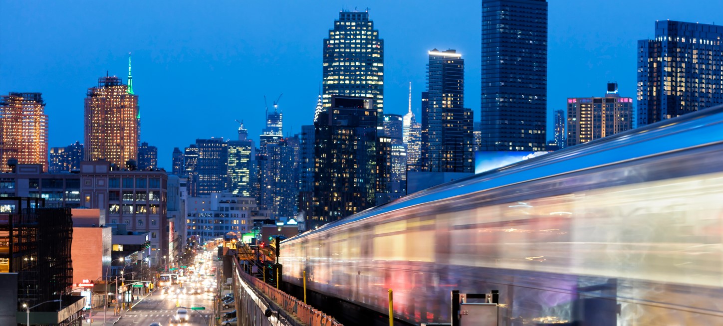 Blurry train driving through city at night