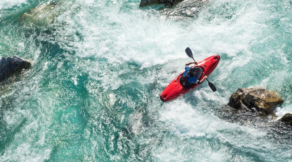 Areal view of red kayak paddling through violent waters