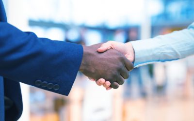 Business people shaking hands with each other in corridor at office Mid section close-up of diverse Business people shaking hands with each other in corridor at office. International diverse corporate business partnership concept